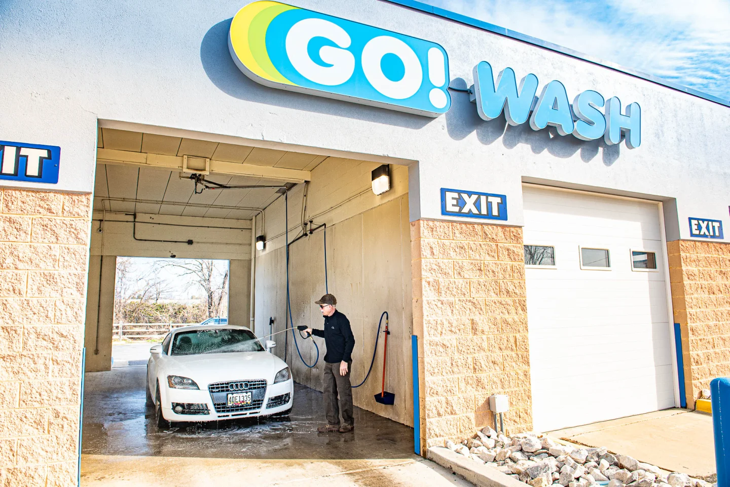 GO! Wash Easton II attendant washing a white Audi at the bay entrance
