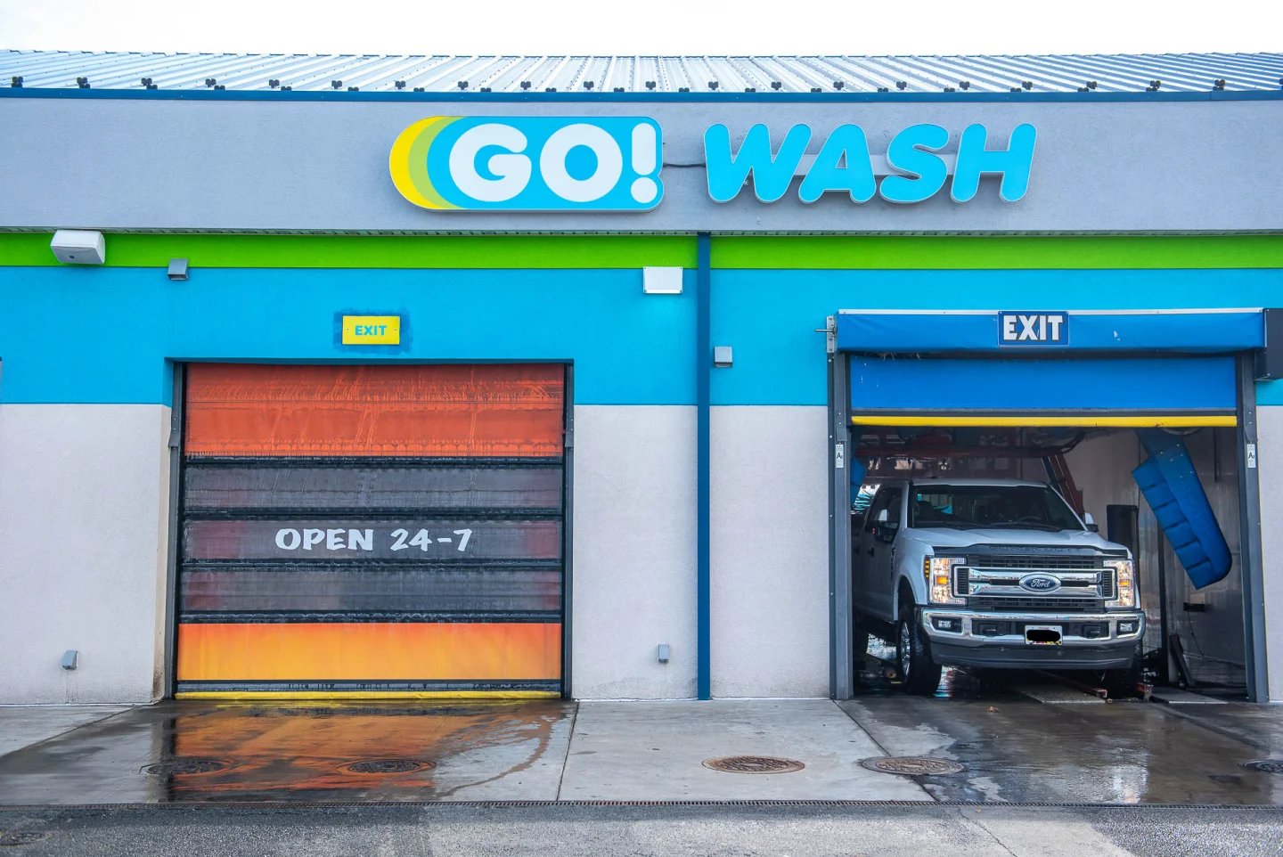GO! Wash Easton II building front showing the OPEN 24-7 door art and both touchless wash bays
