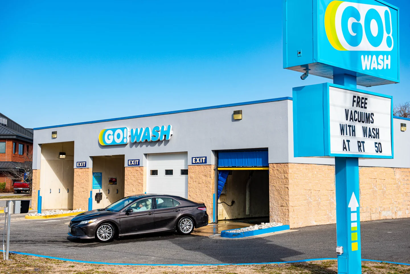 GO! Wash Easton II exterior with the road sign advertising free vacuums and a car entering the bay
