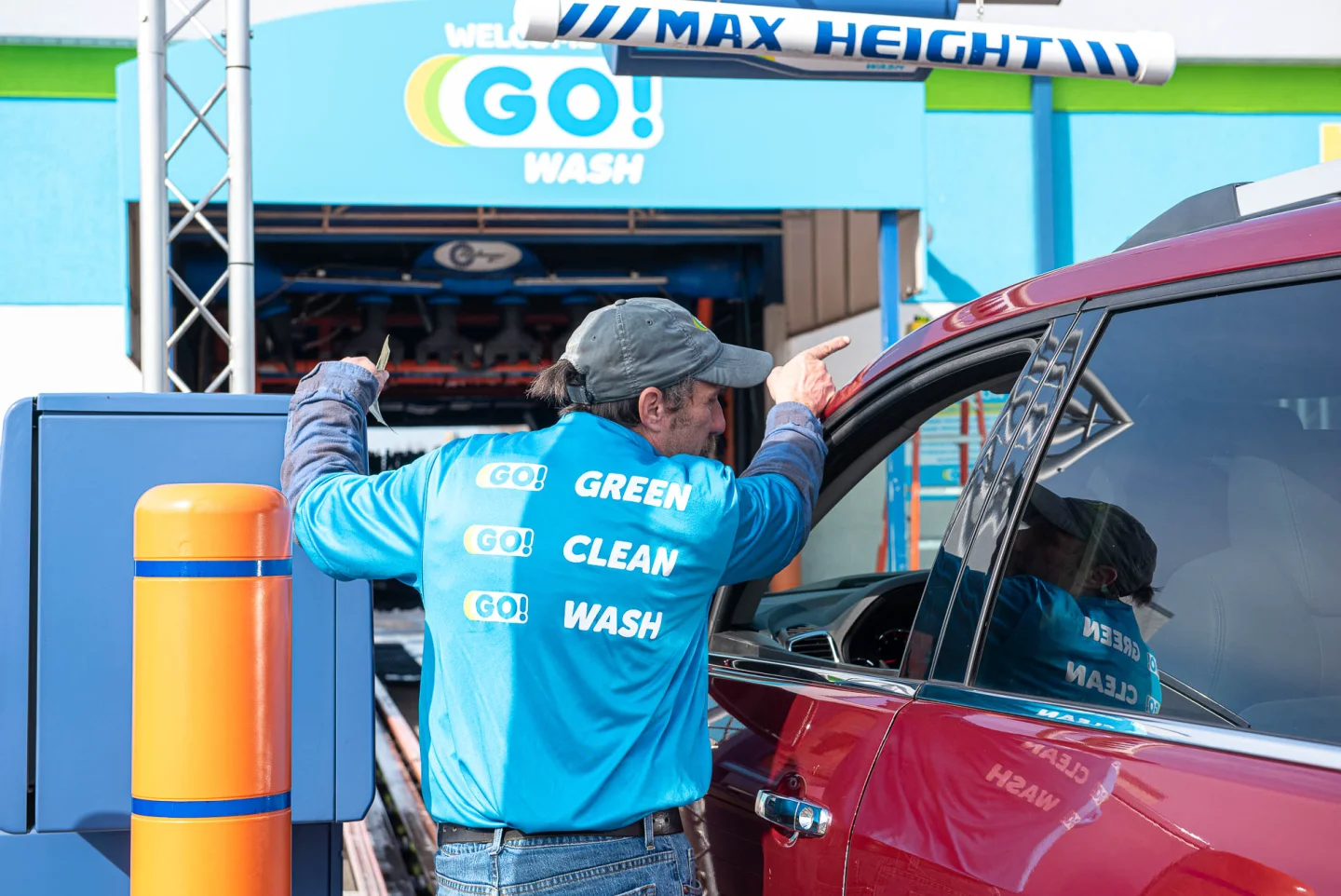 GO! Wash Easton attendant checking in a customer at the tunnel entrance
