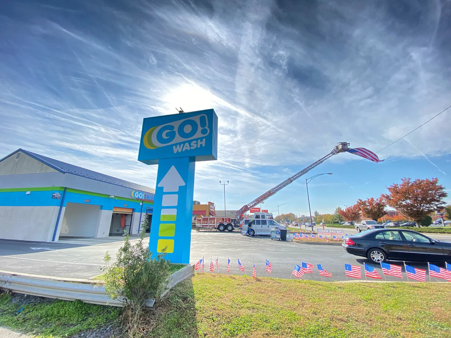 GO! Wash Easton sign with a firetruck raising a large American flag during a community event